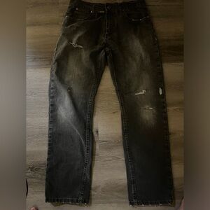 Black distressed denim jeans with a grunge vibe